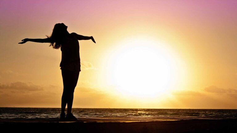 What really matters in life - Girl standing at the seashore during sunrise